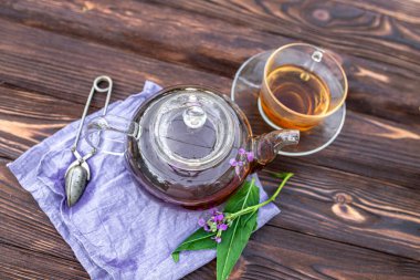 Kettle with herbal tea and fresh leaves Matthiola incana, Brompton stock, common stock, hoary stock, ten-week stock, and gilly-flower tea with fresh quotes, which can give an antiseptic effect.