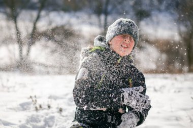 Kar dağında kızaklı, kayak kıyafeti giymiş bir çocuk. Çocuk bir kızak scooterına biniyor. Sokakta aktif oyunlar. Kış günü sağlıklı bir yaşam tarzı.