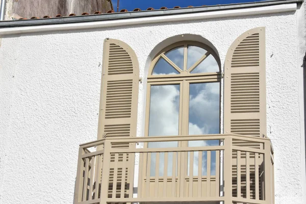 typical Pornic window with half-moon wooden shutter and sky