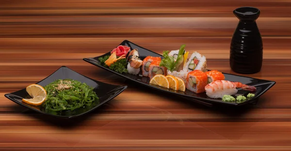 Sushi på en svart plåt — Stockfoto