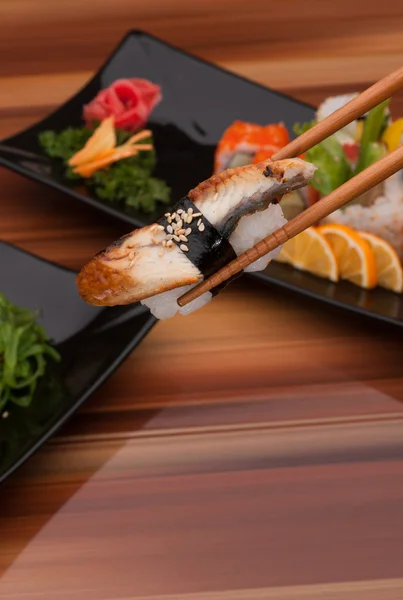 Sushi på en svart plåt — Stockfoto