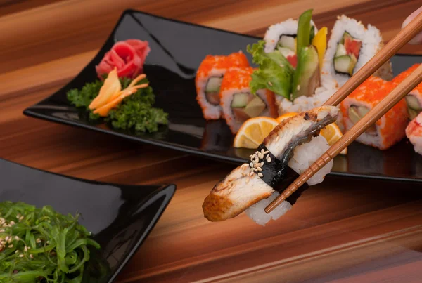 Sushi på en svart plåt — Stockfoto