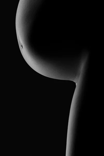 Magen på en gravid kvinna på en mörk bakgrund — Stockfoto