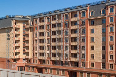 Yeni bir konut binasının ön cephesinde bitirme çalışmaları