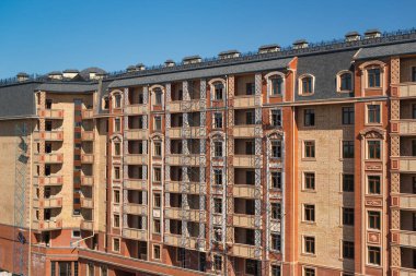 Yeni bir konut binasının ön cephesinde bitirme çalışmaları