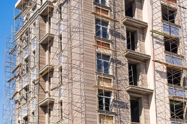 Yeni bir konut binasının ön cephesinde bitirme çalışmaları