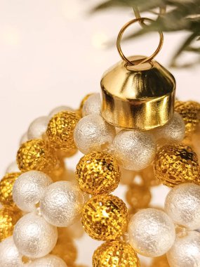 Beyaz ve altın boncuklardan yapılmış el yapımı bir Noel balosu. Makro ve kırpılmış fotoğraf