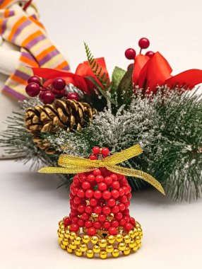 Noel ve yeni yıl süsü olarak süslenmiş, altın ve kırmızı renkte el yapımı çan süsü. Sıcak kış tatili dekor konsepti