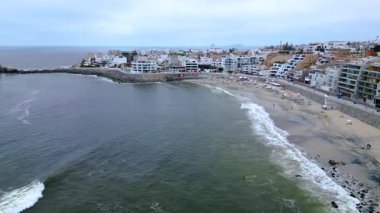 Punta Hermosa plajı ve kıyı kasabasının sakin bir yaz boyunca yüksek irtifa drone görüntüsü.