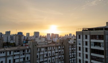 Yoğun şehir Lima siluetinin üzerinde sarı tonlu günbatımı.