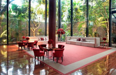 details of an exuberant and luxurious wedding party in a large hall, with candles, flowers and tables decorated in shades of red.