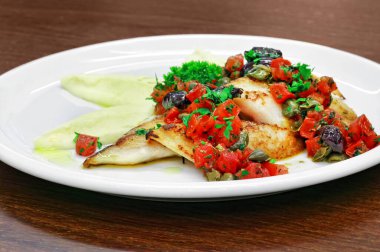 ızgara balık filetosu, yanında püre ve domates sosu doğranmış domates ve siyah zeytin.