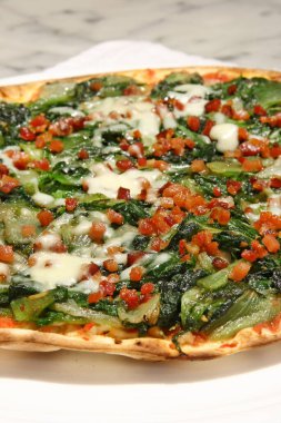 Kızarmış pastırma ve mozzarella peynirli salatalı pizza.