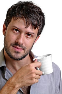 Genç yönetici kahvesini içerken gayri resmi poz veriyor.