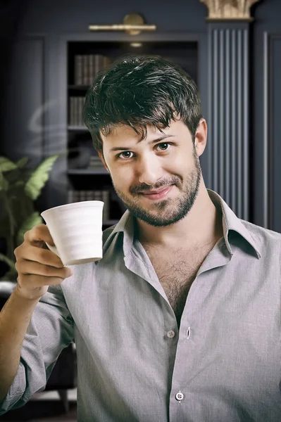 Genç yönetici kahvesini içerken gayri resmi poz veriyor.