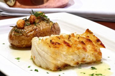 Tavada patates ve kızarmış morina filetosu.