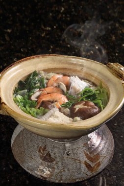 Yosenabe is a stew of meats, seafood, and vegetables. It includes fish, chicken thighs, squid, shrimp, harusame noodles, kamaboko noodles, and tofu, among other ingredients.