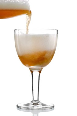 Soğuk bira beyaz arka planı olan özel bir bardakta servis ediliyor..