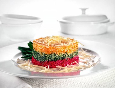 Ispanaklı, havuçlu ve pancarlı renkli pirinç, patates kızartması ile süslenmiş..