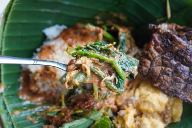 Nasi Pecel Madiun, 16 Kasım 2025 'te yakalandı. Taze sebze, baharatlı fıstık sosu, sığır ciğeri ve çıtır kraker ile servis edilen pilav, klasik Endonezya yemeği.