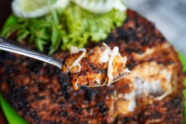 Izgara Red Snapper, taze balık aromatik baharatlar, limon ve sambal, canlı Endonezya kıyı tatları ile kavrulmuş.