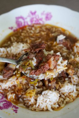 Rawon ev usulü, sıcak keluak aromalı zengin siyah et çorbası, taze dilimler, mis kokulu otlar ve sağlıklı Endonezya yemeği görselleri için uygun buharda pişirilmiş pirinç üzerine rahatlatıcı Cava derinliği.