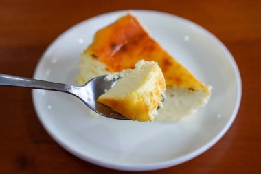 Yanmış cheesecake, kremalı krema gibi bir merkez, derin karamelize edilmiş üst, zengin aroma, ince tatlılık, ve sıcak, davetkar yemek imgeleri için uygun rustik kaf tarzı tatlı görselleri.