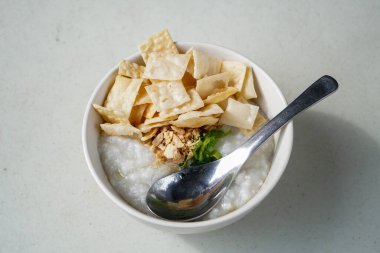 Lezzetli çorba, taze doğranmış tavuk, gevrek wonton krakeri ve hafif malzemeler, Endonezya kahvaltı tabağı, zengin desenli ve basit sokak yemeği görselleri.