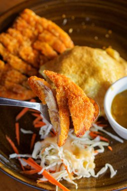 Buharda pişmiş pirinçli körili tavuk omleti, kızarmış tavuk pirzolası ve zengin Japon köri sosu, temiz kaplama sunumuyla modern kafein yemeğini rahatlatıyor.