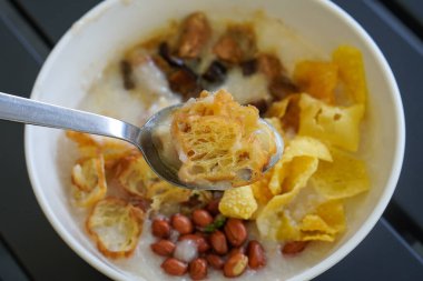 Tavuk ve mantarlı pirinç lapası kremalı yumuşak dokuma, lezzetli soslar, çıtır çıtır krakerler, fıstık, otlar ve sıcak rahatlatıcı bir tat, taze iştah açıcı sunumuyla modern Asya kahvaltı yemeği.