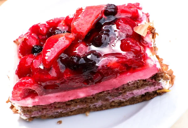 Delicious slice wild berry cake with different fruits and chocolate cream — Stock Photo, Image