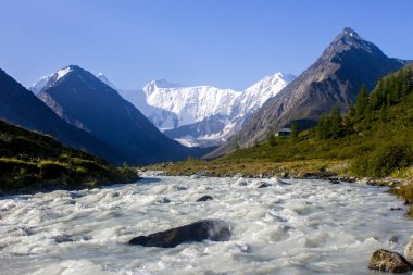 Sabah, arka planda karlı, aydınlanmış güneş ışığıyla birlikte...