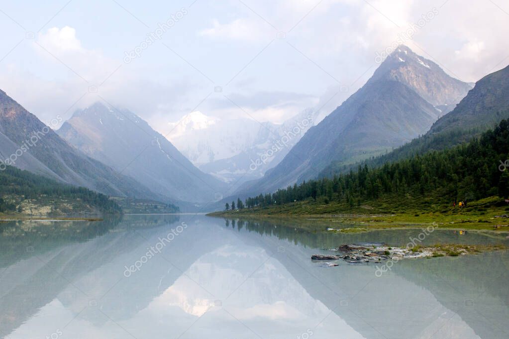 Scenic mountain lake reflect mountain range and fir wood