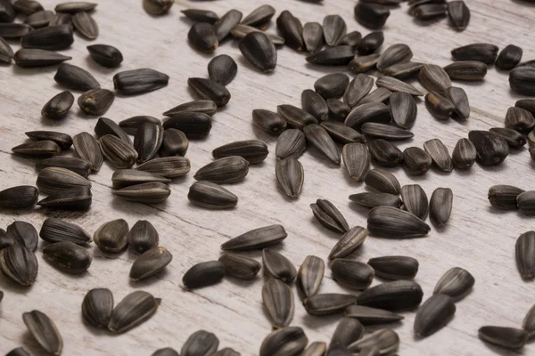Sunflower seeds on bright wooden background — Stock Photo, Image