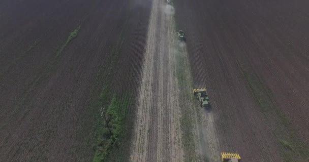 Aéreo: Colheita de girassóis no campo com ceifeiras-debulhadoras. Nuvens de poeira e fumaça das colheitadeiras — Vídeo de Stock