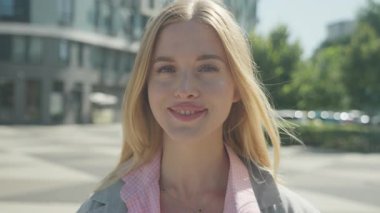 Elegant Modern Young Woman Enjoying Sunny Day On Stylish City Street. Confident Female Model In Trendy Outfit Walking Outdoors With Graceful Expression, Natural Makeup And Urban Charm