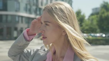 Elegant Woman Exploring Bright Urban Streets With Elegant Confidence. Stylish Blonde Model Walking Outdoors On Sunny Day, Radiating Poise, Beauty, And Modern Sophistication. High quality 4k footage