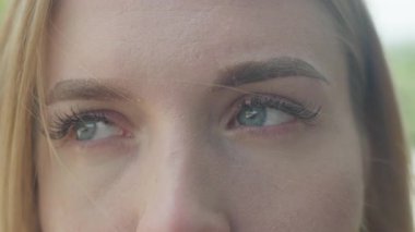 Etrafa kurnaz duygusal ifadeyle bakan kadın gözlerini kapat. Büyüleyici Makro Çekim Mavi Gözler Değişken Bakış Parlak Şehir Işığında Zarif Duygu