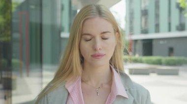 Yüzü örten ve dışarıda kameraya gülümseyen oyuncu genç kadın. Günümüz kentsel ortamında neşeli kadın neşe ve neşe ifade ediyor ve neşe katıyor.