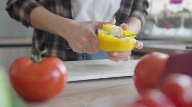 Modern Mutfak 'ta Taze Salata Hazırlamak için Sarı Biber Temizleme. Parlak İçindekiler, Doğal Işık, Yiyecek İçeriği İçin Konforlu Ev Ortamı, Yemek Tarifi Blogları Sağlıklı Yemek Süreci