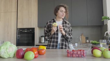 Kıvırcık Kadın Taze Elma Seçiyor ve Ev Mutfağında Meyve Hazırlıyor. Sağlıklı Yaşam Tarzı, Organik Gıda, Doğal Yaşam, Sabah Rutini, Taze Ürün, Çevre Konsepti, Dengeli Beslenme, Ev Yemeği