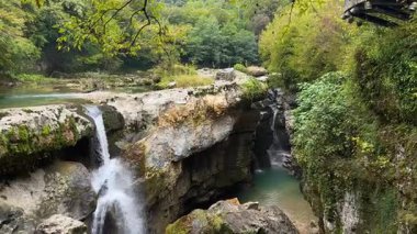 Martvili Kanyonu 'nu keşfedin: çarpıcı şelaleler, sakin turkuaz havuzlar, canlı yosunlar, yoğun yapraklar. Nefes kesici, el değmemiş doğal bir cennet..
