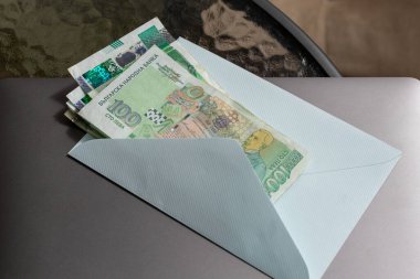 Tanınmış bir 100 Lev faturası da dahil olmak üzere bir yığın Bulgar Lev banknotu, Bulgaristan 'ın Avro Geçişi yolundaki mali geçişini simgeleyen açık bir zarfın içinde bulunuyor..