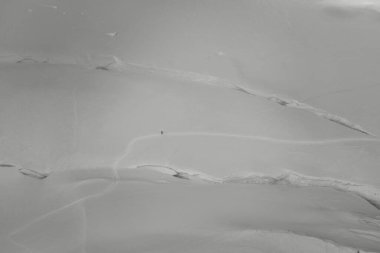 Yalnız dağcı, Mont Blanc 'a tırmanıyor. Büyük karlı bir arazide, siyah beyaz.