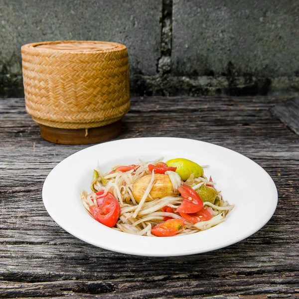 Ahşap bir masa üzerinde papaya salatası (Som tum Tay dili).