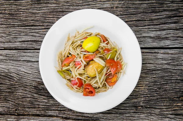 Ahşap bir masa üzerinde papaya salatası (Som tum Tay dili).