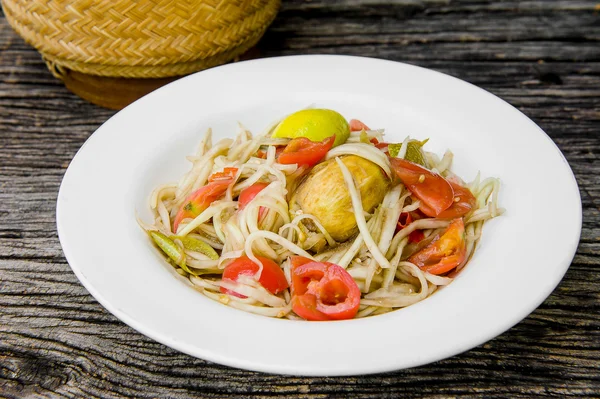 Ahşap bir masa üzerinde papaya salatası (Som tum Tay dili).