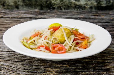 Ahşap bir masa üzerinde papaya salatası (Som tum Tay dili).