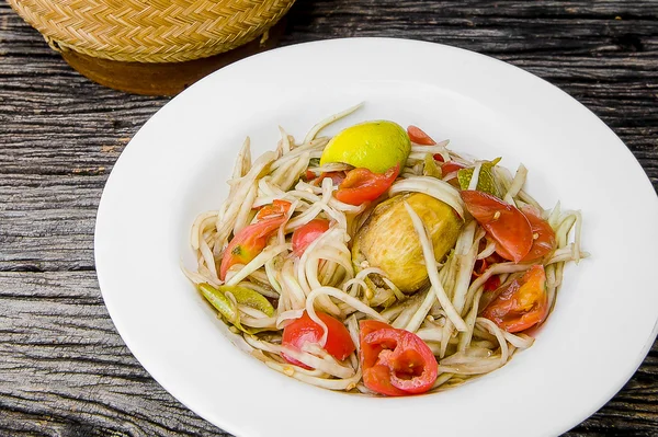 Ahşap bir masa üzerinde papaya salatası (Som tum Tay dili).