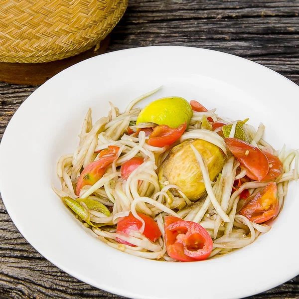 Ahşap bir masa üzerinde papaya salatası (Som tum Tay dili).